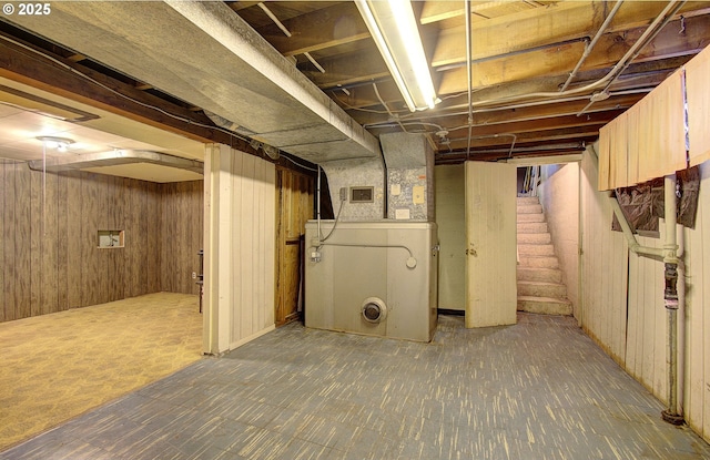 unfinished below grade area with stairs, visible vents, and wooden walls