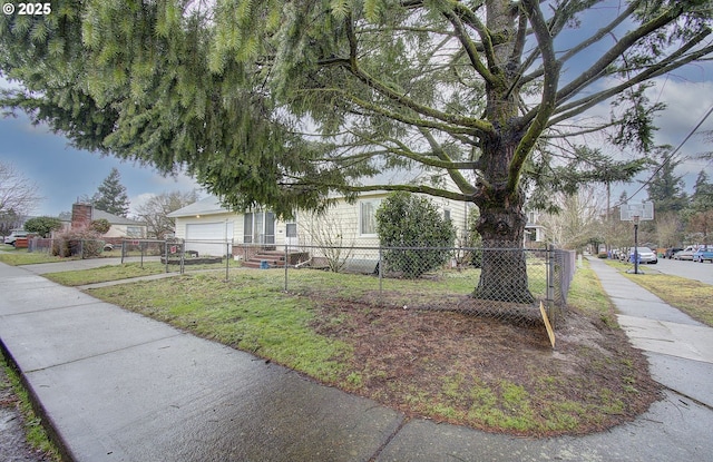 view of property hidden behind natural elements featuring a garage and fence