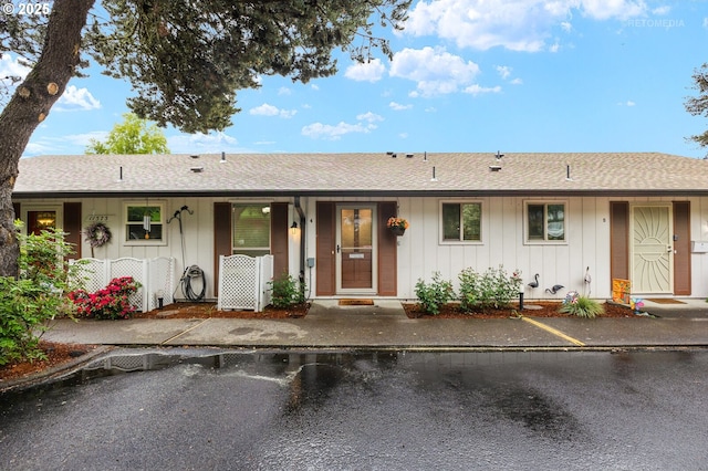 single story home featuring board and batten siding and a shingled roof