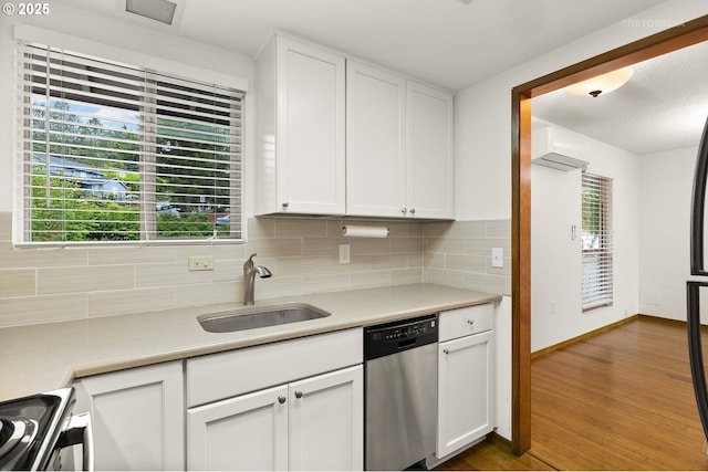 kitchen with stainless steel dishwasher, a sink, range, and light countertops