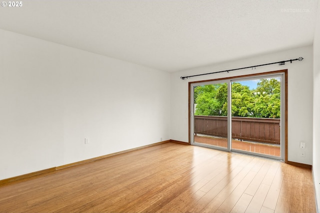 spare room with light wood finished floors and baseboards