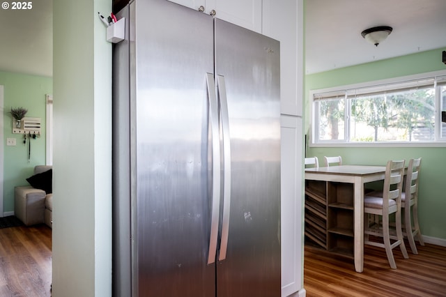 kitchen featuring white cabinetry, stainless steel fridge, and hardwood / wood-style floors