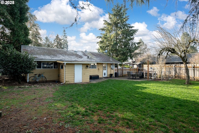 back of house with a patio and a lawn