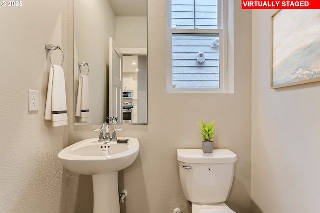 bathroom with a healthy amount of sunlight and toilet