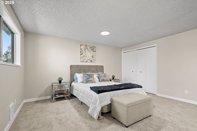 carpeted bedroom featuring a closet and a textured ceiling