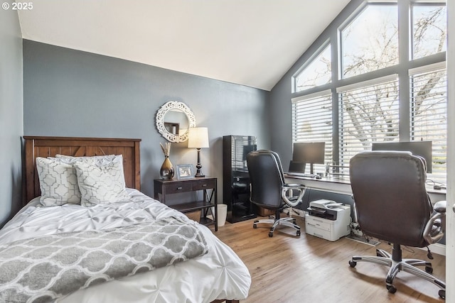 bedroom with lofted ceiling and light wood-type flooring