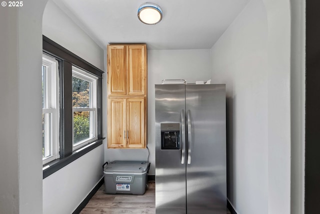 kitchen with stainless steel fridge, baseboards, and wood finished floors