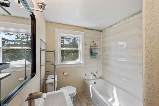 full bath featuring toilet, shower / washtub combination, and wood finished floors