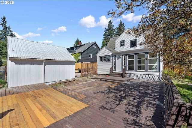 rear view of property with a wooden deck, fence, and entry steps