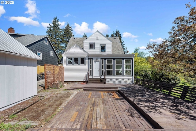 rear view of house with roof with shingles, a wooden deck, and entry steps