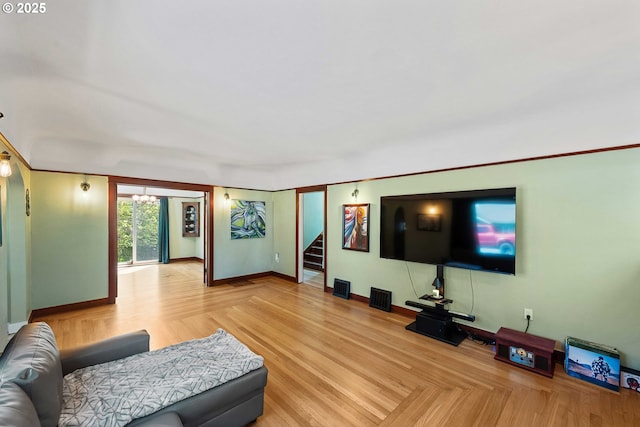 living room with stairway, baseboards, and visible vents