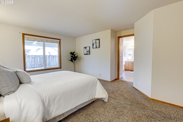 bedroom featuring connected bathroom and carpet