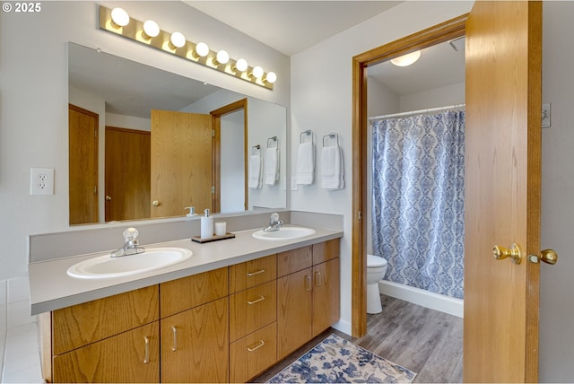 bathroom with vanity, toilet, and wood-type flooring