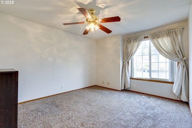 carpeted spare room featuring ceiling fan