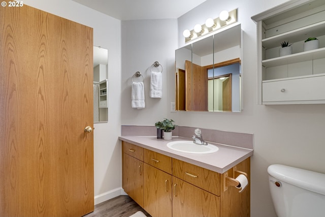 bathroom with wood-type flooring, toilet, and vanity