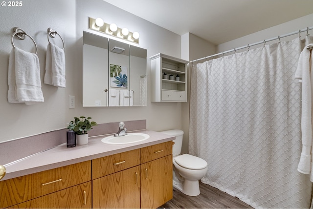 bathroom with hardwood / wood-style floors, toilet, and vanity