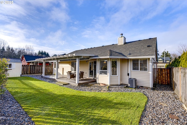 rear view of house featuring cooling unit, a storage shed, a lawn, and a patio