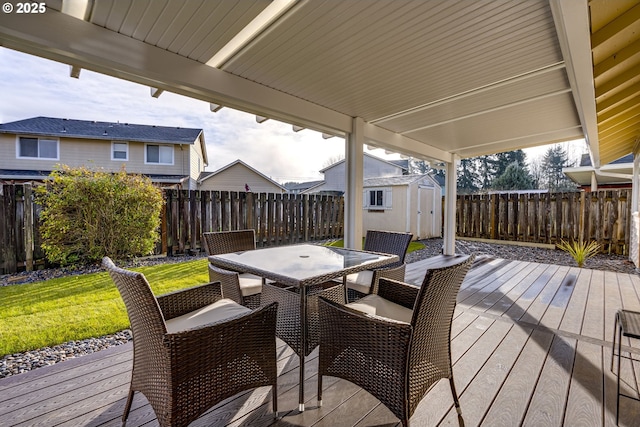 wooden terrace featuring a storage shed and a yard