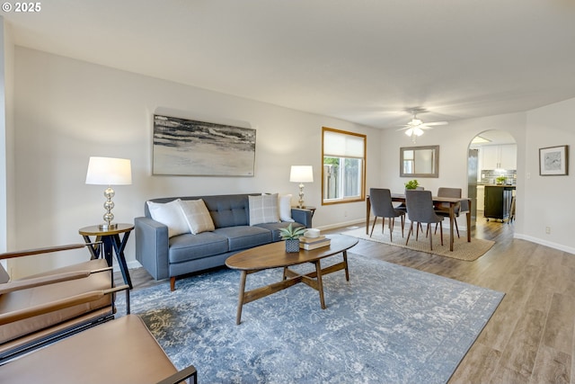 living room with ceiling fan and light hardwood / wood-style flooring