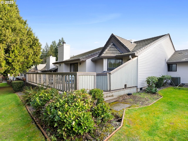 rear view of house with a deck, central AC unit, and a lawn