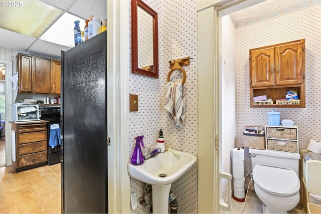 3235 NE 65th Ave, Portland, OR 97213 - bathroom with wood finished floors, toilet, wallpapered walls, and a sink
