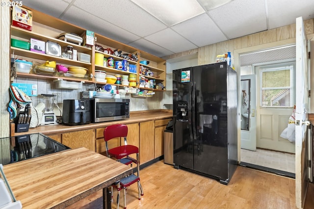 3235 NE 65th Ave, Portland, OR 97213 - kitchen with black fridge with ice dispenser, stainless steel microwave, open shelves, light wood-type flooring, and a paneled ceiling