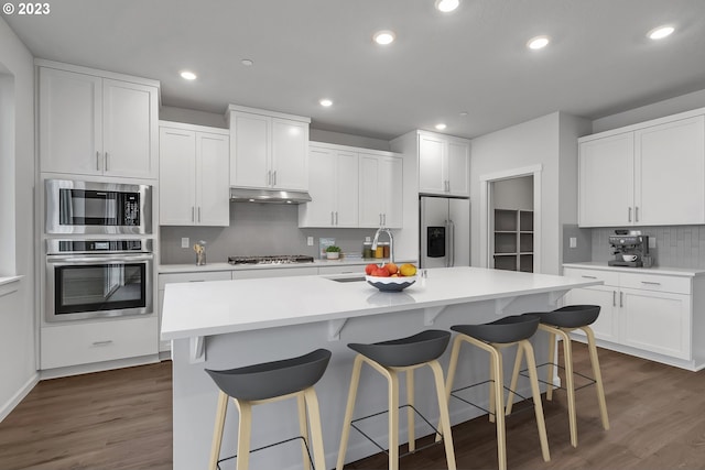 2604 S 8th Way, Ridgefield, WA 98642 - kitchen with appliances with stainless steel finishes, under cabinet range hood, tasteful backsplash, dark wood-style floors, and recessed lighting