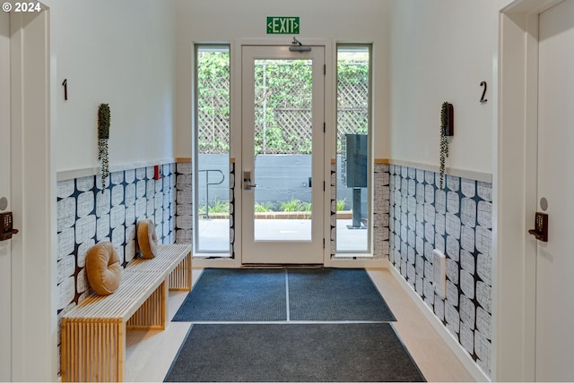 doorway to outside featuring tile walls