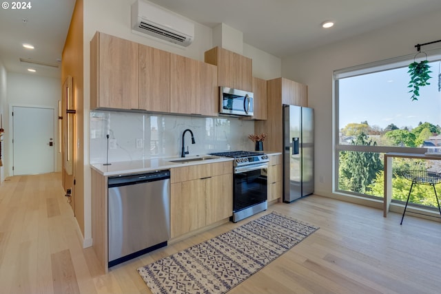 kitchen with sink, stainless steel appliances, a wall mounted AC, tasteful backsplash, and light brown cabinetry