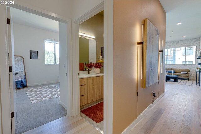 hallway with sink and light hardwood / wood-style floors