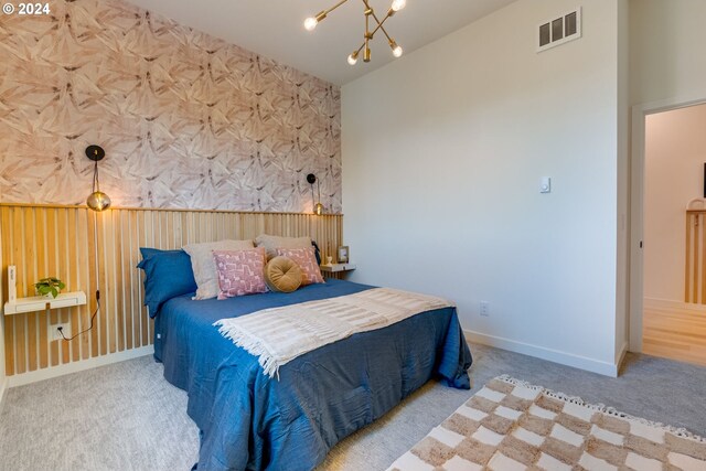 bedroom with an inviting chandelier and light colored carpet