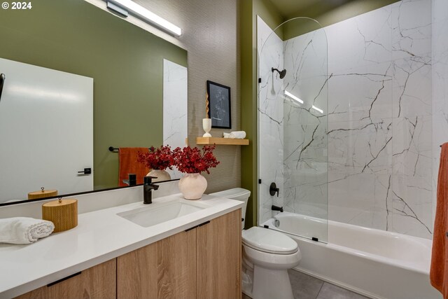 full bathroom featuring vanity, tile patterned flooring, toilet, and tiled shower / bath