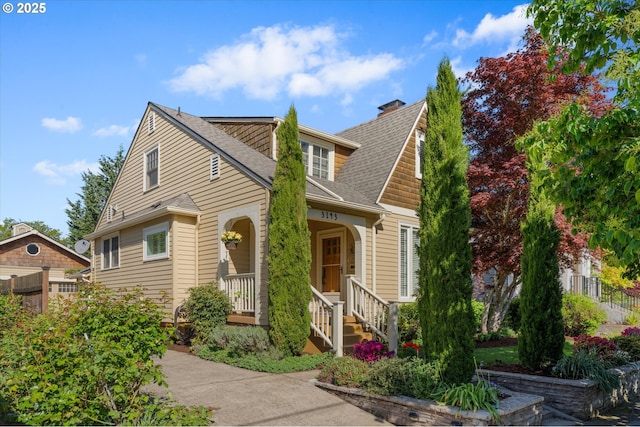 view of front of property with fence and a shingled roof