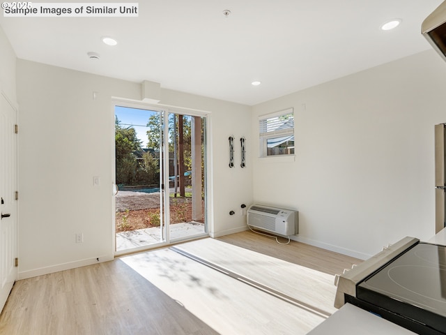 doorway to outside with baseboards, light wood finished floors, recessed lighting, and a wall mounted AC