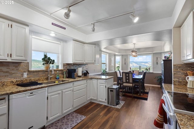 kitchen with white appliances, sink, hanging light fixtures, and white cabinets