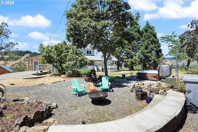 view of yard featuring an outdoor fire pit and a hot tub