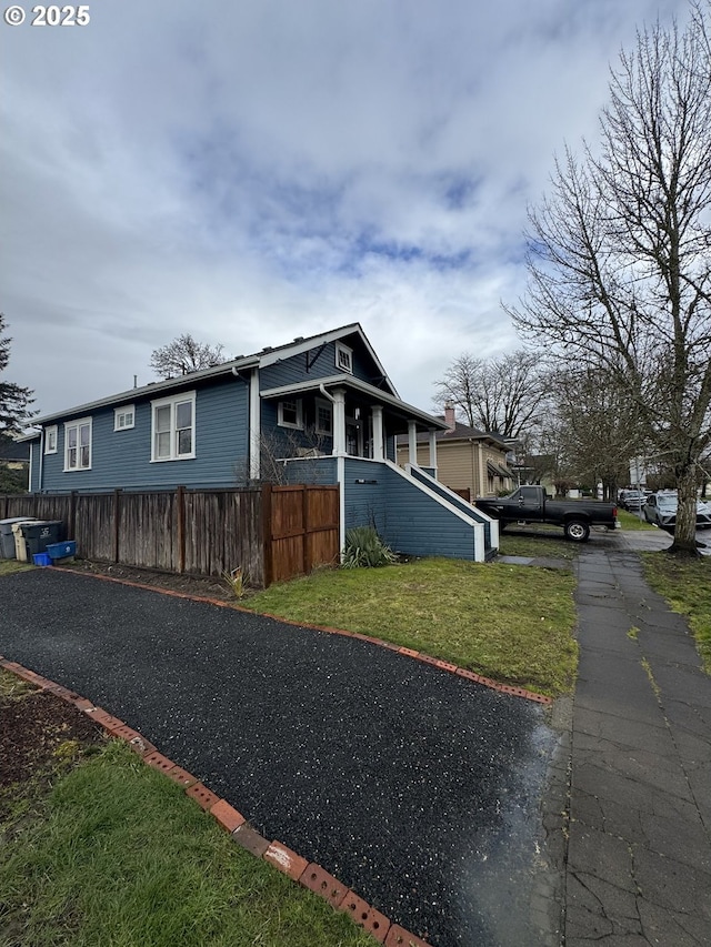 view of side of home with a lawn and fence