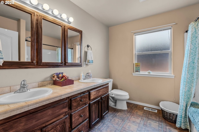 719 NE Quince Ave, Redmond, OR 97756 - full bathroom with double vanity, baseboards, toilet, a shower with shower curtain, and a tub to relax in
