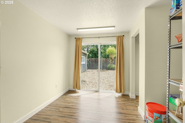 2472 Willamina Ave, Forest Grove, OR 97116 - empty room featuring wood finished floors, a textured ceiling, and baseboards