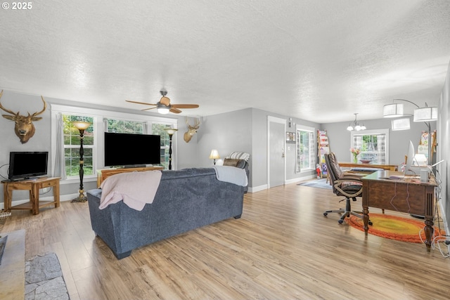 2472 Willamina Ave, Forest Grove, OR 97116 - living area with light wood finished floors, a textured ceiling, ceiling fan, baseboards, and a chandelier