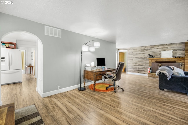 2472 Willamina Ave, Forest Grove, OR 97116 - office space featuring arched walkways, an accent wall, wood finished floors, baseboards, and wooden walls
