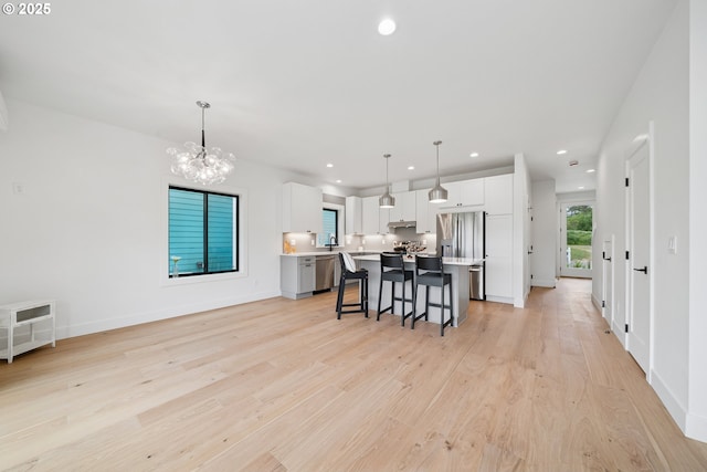 42 Washington St, Rockaway Beach, OR 97136 - kitchen featuring appliances with stainless steel finishes, light countertops, a kitchen island, a breakfast bar area, and a chandelier