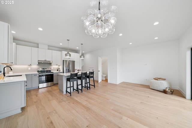 42 Washington St, Rockaway Beach, OR 97136 - kitchen featuring stainless steel appliances, a kitchen bar, recessed lighting, light countertops, and under cabinet range hood