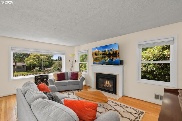 4545 SW Poplar Ln, Portland, OR 97225 - living room with a textured ceiling, a fireplace with flush hearth, and wood finished floors