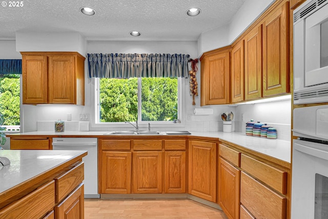 12459 SE Imperial Crest St, Happy Valley, OR 97086 - kitchen with white appliances, light countertops, plenty of natural light, brown cabinetry, and a textured ceiling