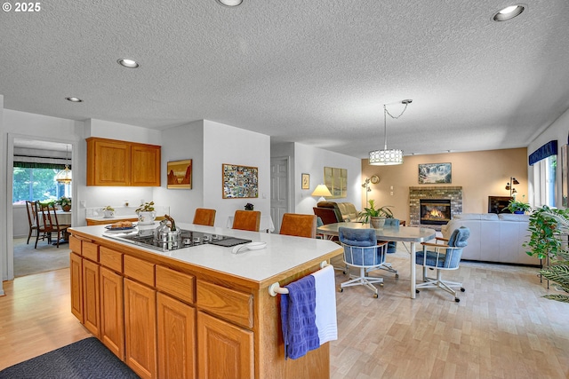 12459 SE Imperial Crest St, Happy Valley, OR 97086 - kitchen featuring open floor plan, healthy amount of natural light, light wood-style flooring, a textured ceiling, and a kitchen island