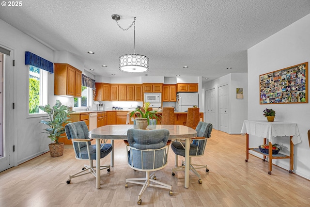 12459 SE Imperial Crest St, Happy Valley, OR 97086 - dining area featuring a textured ceiling, light wood finished floors, recessed lighting, and baseboards