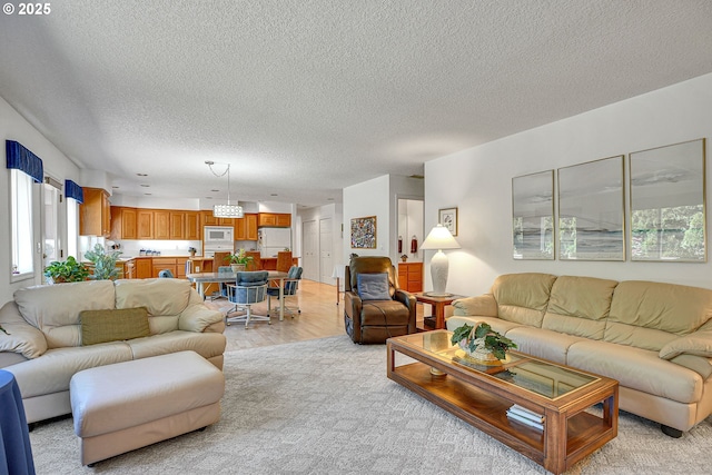 12459 SE Imperial Crest St, Happy Valley, OR 97086 - living room with a textured ceiling, light wood finished floors, and a chandelier