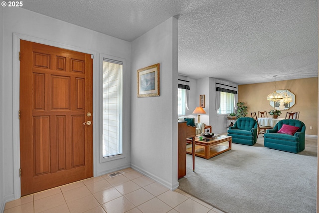 12459 SE Imperial Crest St, Happy Valley, OR 97086 - foyer entrance with a chandelier, baseboards, a textured ceiling, light tile patterned floors, and light carpet