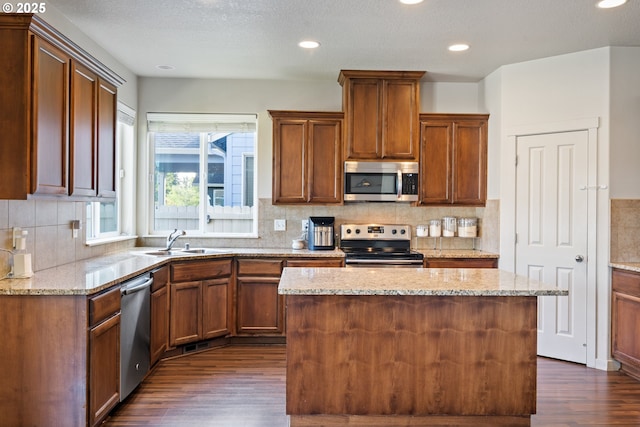 6916 NE 104th Way, Vancouver, WA 98686 - kitchen with dark wood-style flooring, light stone countertops, a sink, appliances with stainless steel finishes, and backsplash
